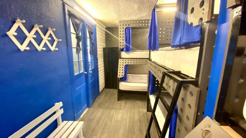 a blue room with a bunk bed and a door at ROOMIES HOSTEL Roma in Mexico City