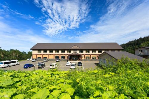 a large building with cars parked in a parking lot at Kamihoroso in Kami-furano