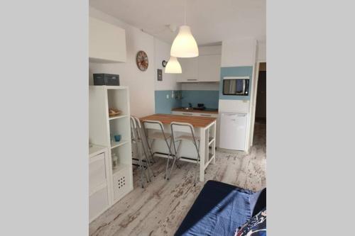 a kitchen and dining room with a table and chairs at Studio Cabine pied pistes Pyrénées 2000 rénové - 3 in Bolquere Pyrenees 2000