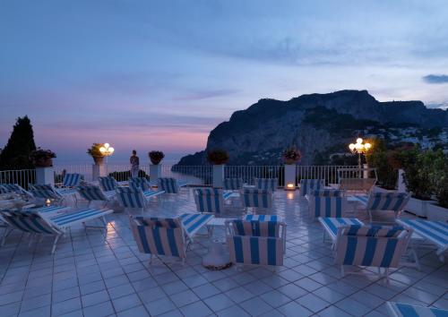 a group of chairs sitting on a patio at night at Hotel Villa Brunella in Capri