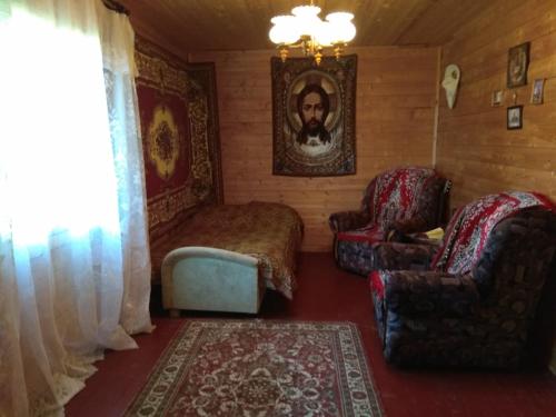 um quarto com uma cama, 2 cadeiras e um tapete em Небольшой Домик в Абхазии в 6 минутах от моря с прекрасным видом em Novy Afon