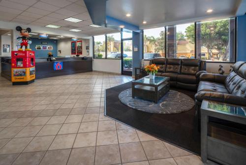 a waiting room with a leather couch and a table at Motel 6-Anaheim, CA - Maingate in Anaheim