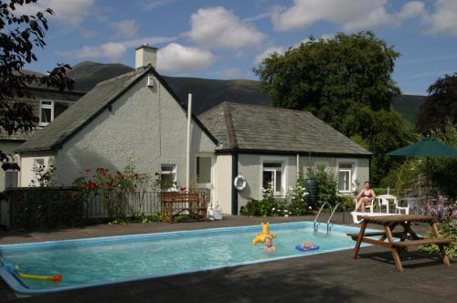 a house with a swimming pool in front of a house at Skiddaw Grove in Keswick