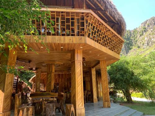 a wooden building with a balcony on top of it at Hang Lan Bungalow in Ninh Binh