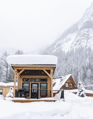 a cabin with a snow covered roof in the snow at Boulder Mountain Resort in Revelstoke