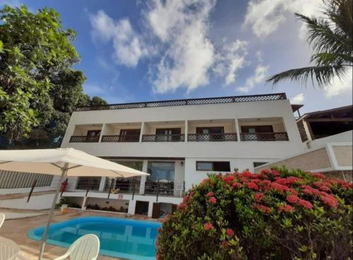 a villa with a swimming pool and a resort at Pousada Ceu e Mar in Pipa