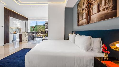a bedroom with a large white bed and a kitchen at PIER 57 - 711 Fabulous & Dreamy 1 BR Romantic Zone in Puerto Vallarta
