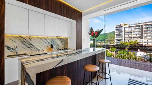a kitchen with a counter with stools and a large window at PIER 57 - 711 Fabulous & Dreamy 1 BR Romantic Zone in Puerto Vallarta
