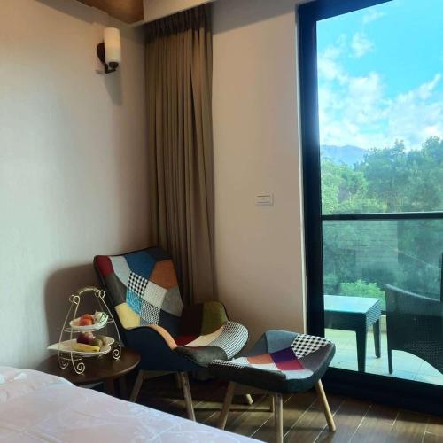 a hotel room with two chairs and a large window at 山水奇異San Shuei Kiwi桃園市民宿編號038 Homestay in Sanmin