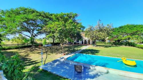 a backyard with a swimming pool and a yard with trees at Kampu Nature Pool Villa Rayong in Rayong