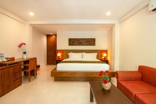 een hotelkamer met een bed en een bank bij Diva Lombok Resort in Senggigi 