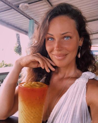 a woman is holding a drink in front of herself at Cafe de la Suerte in Pavones