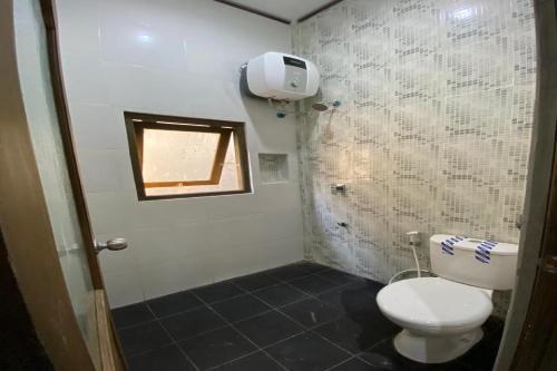 un piccolo bagno con servizi igienici e finestra di RedDoorz near Mojokerto Train Station 