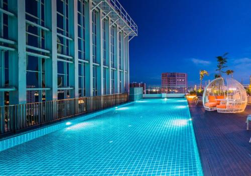 - une piscine sur le côté du bâtiment la nuit dans l'établissement Suasana Residence by Nest Home, à Johor Bahru