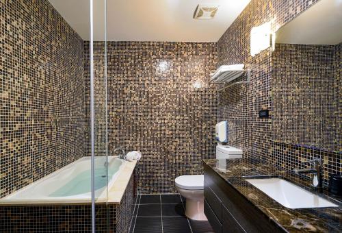 台南市にあるTalmud Hotel Tainanのバスルーム(バスタブ、トイレ、シンク付)