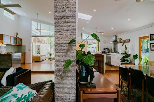 a living room and kitchen with a couch and a table at Pineapple Petes Beach House in Port Douglas