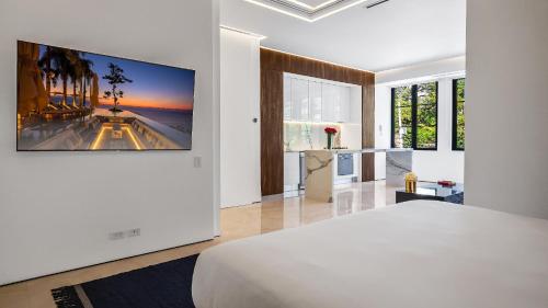 a white bedroom with a tv hanging on a wall at PIER 57 - 211 Luxurious & Modern 1 BR Romantic Zone in Puerto Vallarta