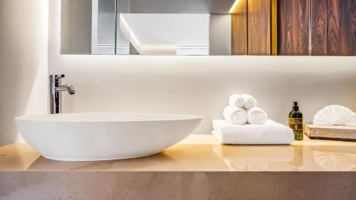 a bathroom with a sink and towels on a counter at PIER 57 - 211 Luxurious & Modern 1 BR Romantic Zone in Puerto Vallarta