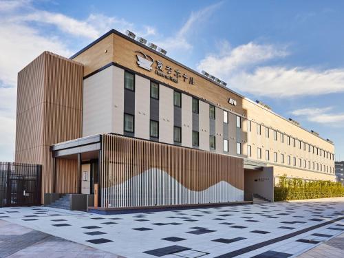 a building with a sign on the front of it at Henn na Hotel Komatsu Ekimae in Komatsu