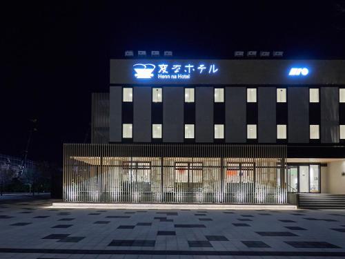 a building with a sign on top of it at night at Henn na Hotel Komatsu Ekimae in Komatsu