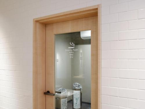 a door to a bathroom with two machines at Henn na Hotel Komatsu Ekimae in Komatsu