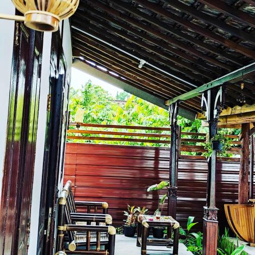 a patio with two chairs and a red door at Omah Kampong in Yogyakarta