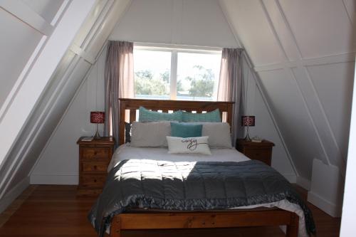 sypialnia z łóżkiem i oknem w obiekcie Classic A-frame on Milford w mieście Te Anau