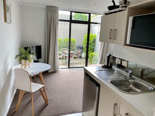 a kitchen with a sink and a table with a table at Alpine Lake Motel in Taupo