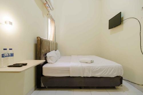 Zimmer mit einem Bett und einem Schreibtisch mit einem TV in der Unterkunft RedDoorz near OPI Mall Palembang 2 in Palembang