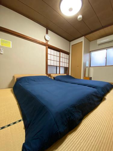 a large blue bed in a room with windows at 縁 Enishi in Hakone