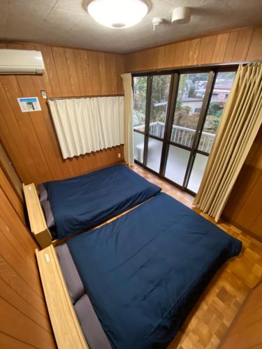 a small room with two beds and a window at 縁 Enishi in Hakone