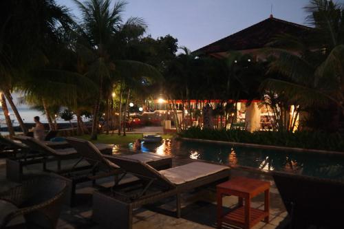 a resort with chairs and a swimming pool at night at 1000 Dream Bungalow in Lovina