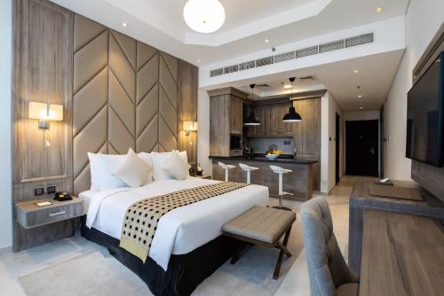 TIME Onyx Hotel Apartments في دبي: غرفة نوم بسرير كبير ومطبخ
