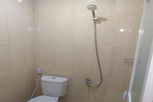 uma casa de banho com duche, WC e chuveiro em Nietsa Guest House Syariah Palu Mitra RedDoorz em Palu