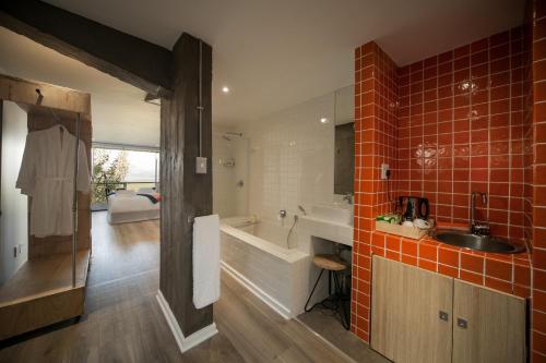 een badkamer met een bad, een wastafel en een bad bij Mister C in Hartbeespoort