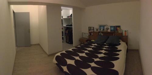 a bedroom with a large black and white bed at Grange de la Menagerie in Mouilleron-le-Captif