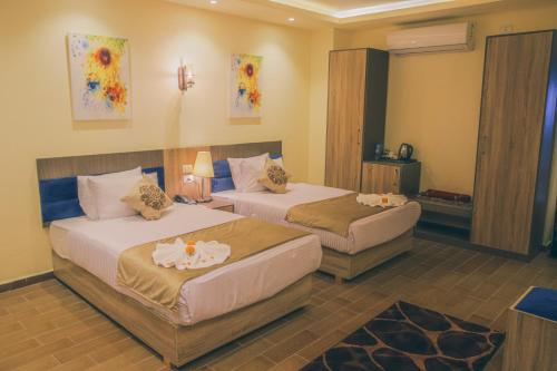 a hotel room with two beds in a room at Jewel Green Mountain Hotel in Cairo
