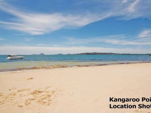 a sandy beach with a boat in the water at Redman Views Unit 1 in Soldiers Point