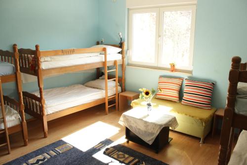 モスタルにあるMajdasの二段ベッド2台とテーブルが備わる客室です。