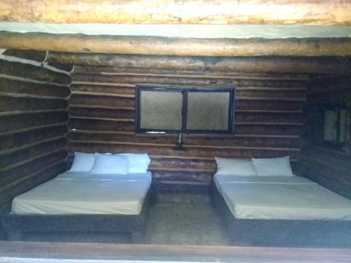 2 camas en una habitación con paredes de madera en Room in Lodge - Sierraverde Huasteca Potosina Cabins Palo De Rosa, en Tamasopo