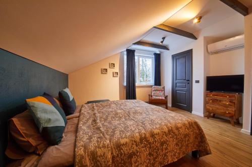 a bedroom with a bed and a dresser and a television at "Parko vila" Anykščiai in Anykščiai