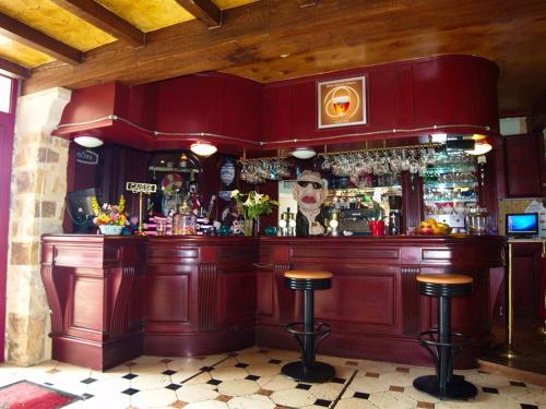 a pub with a red bar with stools at Les Chambres du Sillon in Pleubian