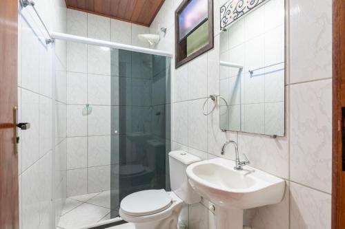 uma casa de banho com um WC, um lavatório e um chuveiro em Hospedagem Cantinho Da Vitoria em Abraão