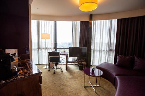a living room with a couch and a tv in a hotel room at Uranus Istanbul Topkapi in Istanbul