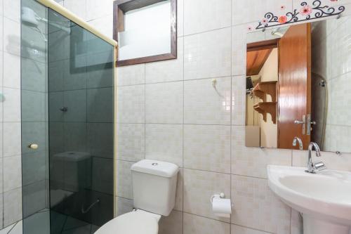 a bathroom with a toilet and a sink and a mirror at Hospedagem Cantinho Da Vitoria in Abraão