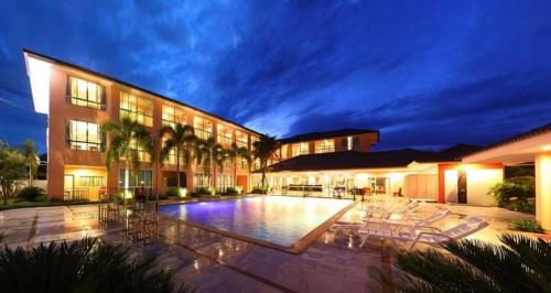 a large building with a swimming pool in front of it at The Victory Hotel in Ban Muang Daeng