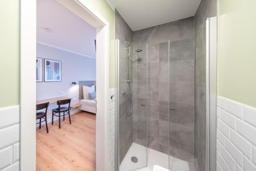 une salle de bain avec douche et une table avec des chaises dans l'établissement The Woodmans Airport Boardinghouse, à Düsseldorf