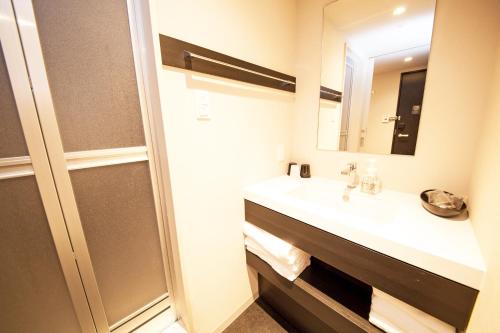 a bathroom with a sink and a mirror at FP HOTELS South-Namba in Osaka