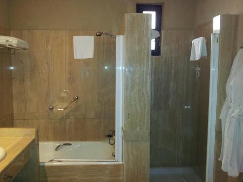 
a bathroom with a shower, sink, and toilet at Parador de Santillana Gil Blas in Santillana del Mar

