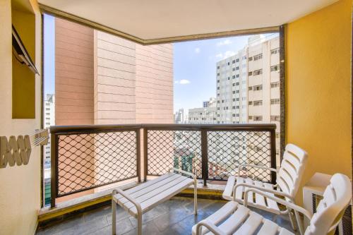 a balcony with two chairs and a view of a building at Park Tower Campinas Residence by Nacional Inn in Campinas